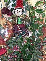 Na choince wiszą małpki w mikołajkowych czapkach